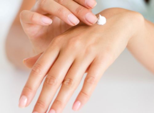 woman applying moisturizing cream to her finger tip