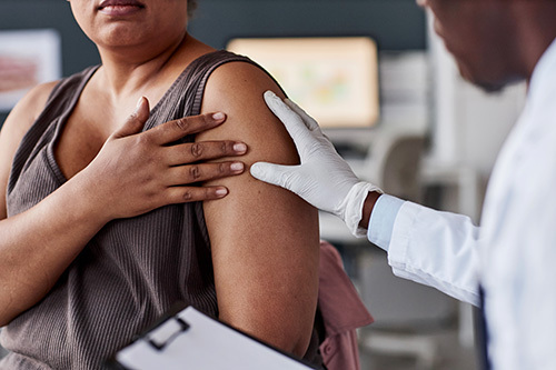 Dermatologist checking out a woman's arm for a chronic skin condition that may be linked to an underlying issue